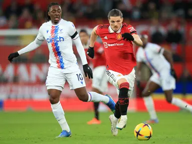Pemain baru Manchester United, Marcel Sabitzer (kanan) berebut bola dengan pemain Crystal Palace, Eberechi Eze pada laga pekan ke-22 Liga Inggris 2022/2023 di Old Trafford, Manchester, Sabtu (04/02/2023). Ini merupakan laga debut Sabtizer setelah dirinya didatangkan dari Bayern Munchen dengan status pinjaman pada bursa transfer Januari 2023. (AFP/Lindsey Parnaby)