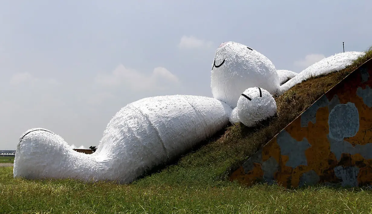 Kelinci raksasa bernama "Moon Rabbit" ini ditampilkan di atas sebuah hanggar pesawat tua dalam Taoyuan Land Art Festival yang dihelat di pangkalan militer, Taiwan, (3/9/2014). (REUTERS/Pichi Chuang)