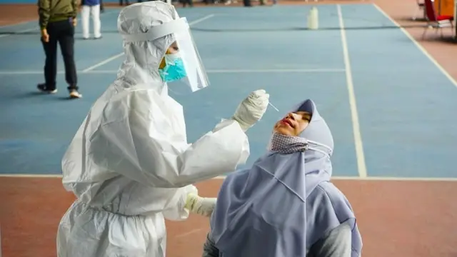 Petugas medis melakukan tes usap atau swab kepada warga di Pekanbaru untuk mendeteksi Covid-19.