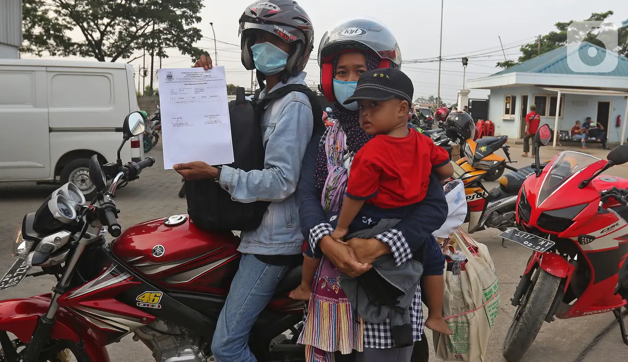 Pengendara motor menunjukkan hasil pemeriksaan tes Swab antigen di pos pemeriksaan kesehatan, Cikarang, Kabupaten Bekasi, Sabtu (22/5/2021). Ada 14 orang dari 4.406 pengendara motor yang terindikasi positif COVID-19 pada arus balik tanggal 16-22 Mei 2021. (Liputan6.com/Herman Zakharia)