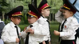 Para taruna muda memeriksa seragam mereka sebelum upacara pada hari pertama sekolah di salah satu sekolah Kadet terbaik, lyceum, di Kiev, Senin (3/9). Ukraina menandai Hari Pengetahuan, sebagai dimulainya tahun ajaran baru. (AP Photo/Efrem Lukatsky)