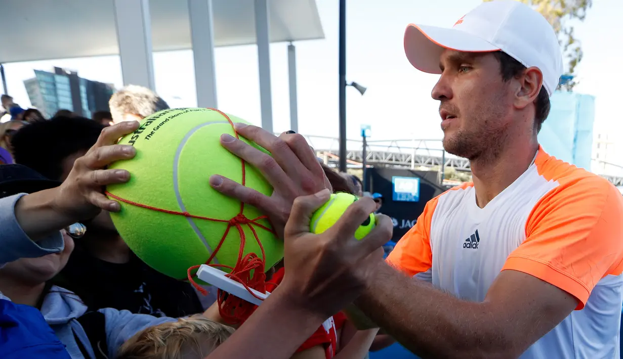 Petenis asal Jerman Mischa Zverev membubuhkan tanda tangan di bola tenis penggemarnya setelah memenangkan pertandingan putaran kedua Australia Terbuka melawan petenis asal AS, John Isner di Melbourne, 17 Januari 2017. (AP Photo/Kin Cheung)