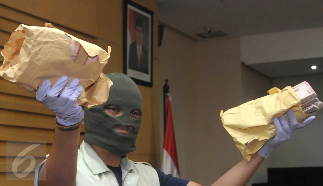 Petugas KPK saat memegang uang sitaan sebesar Rp150 juta sebagai barang bukti di Kantor KPK, Jakarta, (24/5/2016).KPK turut menyita uang Rp650 juta dalam operasi tangkap tangan (OTT) terhadap Ketua PN  Kepahiang, Janner Purba. (Liputan6.com/Helmi Afandi)