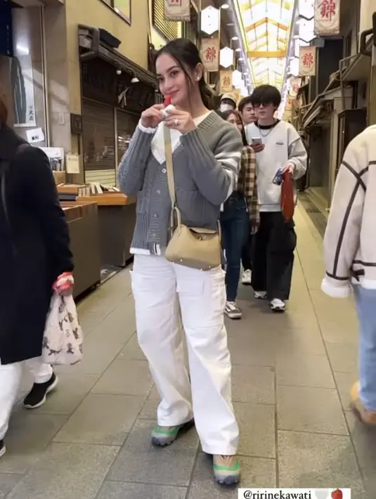 Sambil makan strawberry, Ririn tampil mengenakan cardigan knit abu-abu dipadukan inner dan celana putih. Ia pun mengenakak mini bag Hermes.(@ririnekawati)