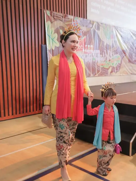 Sementara itu, Shandy mengenakan kebaya kuning dengan selendang orange dipadukan bawahan kain batik yang serasi dengan putrinya. Ia pun memadukannya dengan heels coklat. [@shandyaulia]