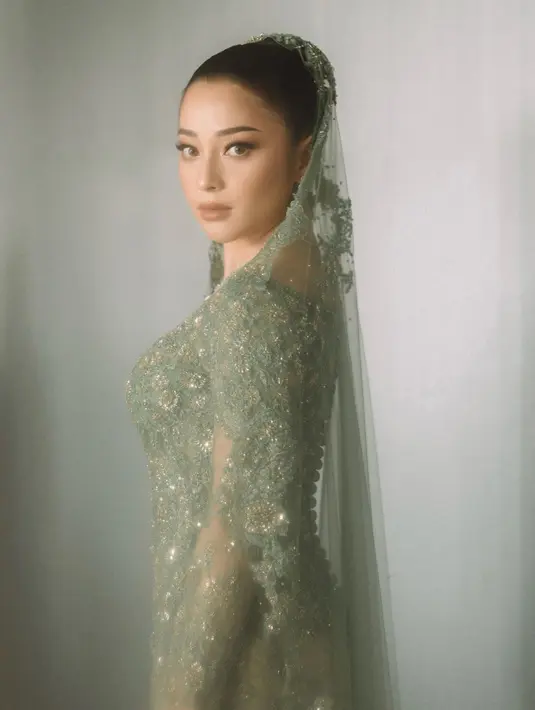 Satu lagi penampilan penuh pesona dari Nikita Willy saat mengenakan kebaya hijau. Ini adalah dari rangkaian acara pernikahannya. Kebayanya dilengkapi dengan veil bernuansa senada yang tak kalah cantik. [Foto: Instagram/svarna_byikatindonesia]