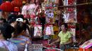 Pelanggan melihat dekorasi di kios pasar jalanan jelang Tahun Baru Imlek di Distrik Pecinan Yangon, Myanmar, 18 Januari 2023. Tahun Baru Imlek 2023 yang disebut sebagai Tahun Kelinci akan jatuh pada tanggal 22 Januari. (STRINGER/AFP)