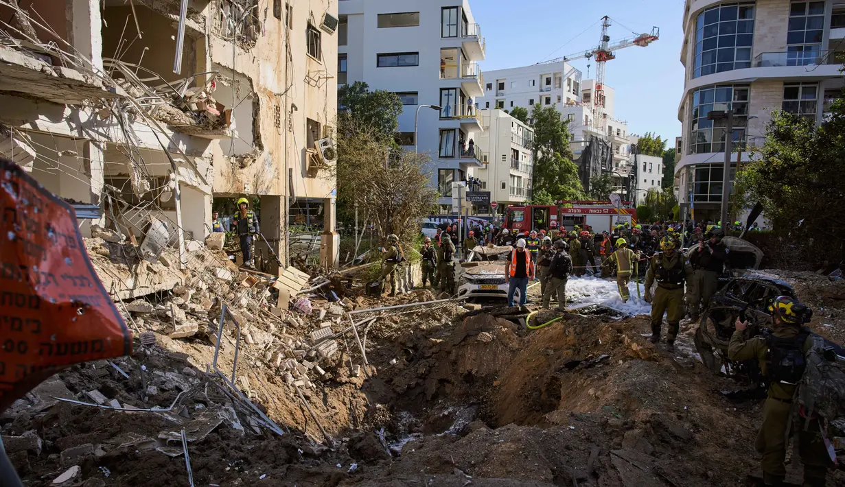 Belum ada informasi tambahan yang disampaikan terkait dampak keseluruhan dari serangan tersebut. Tampak dalam foto, pasukan keamanan Israel dan tim penyelamat memeriksa lokasi serangan rudal Iran di Tel Aviv, Israel, Selasa, 24 Maret 2026. (AP Photo/Oded Balilty)