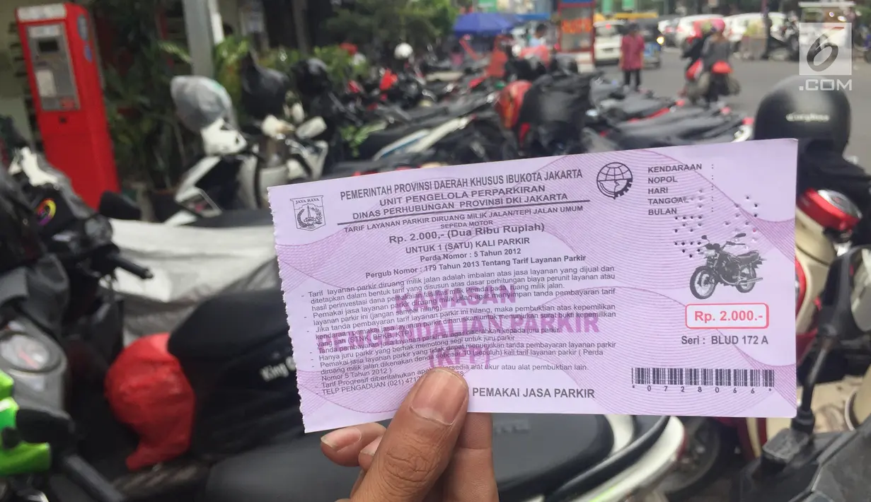 Petugas menunjukkan karcis parkir di Jalan Sabang, Jakarta, Jumat (15/12). Berakhirnya masa kontrak PT Mata Elang Biru selaku pengelola mesin parkir menyebabkan sistem penarikan biaya parkir dilakukan secara manual. (Liputan6.com/Immanuel Antonius)