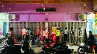 Satgas Covid-19 di Riau membuka toko pakaian yang menutup pintu tapi ramai orang berbelanja di dalam. (Liputan6.com/M Syukur)