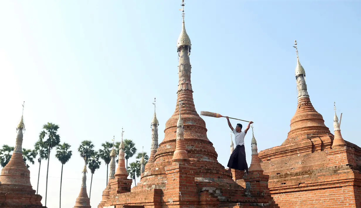 Relawan menyapu pagoda Buddha kuno di Naypyitaw, Myanmar (27/1). Pagoda yang berada di ibu kota negara tersebut dibangun 160 tahun lalu pada masa dinasti Konbaung dan Amarapura. (AP Photo/Aung Shine Oo)