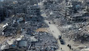 Foto udara memperlihatkan orang-orang berjalan melewati reruntuhan rumah di Rafah, Jalur Gaza Selatan pada 20 Januari 2025. (Foto oleh AFP)