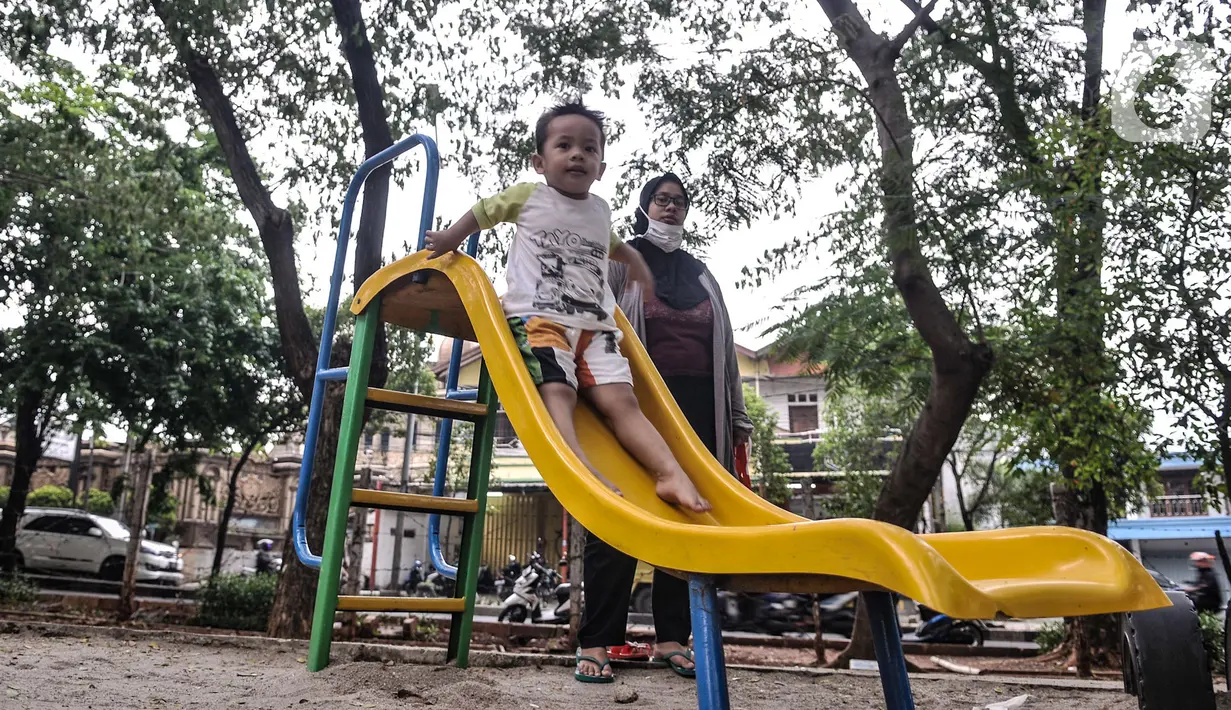 Orang tua mendampingi anak bermain di taman kawasan Duren Sawit, Jakarta, Kamis (26/11/2020). Bermain dengan pendampingan orang tua menumbuhkan potensi kecerdasan secara optimal anak serta menurunkan frekuensi terjadinya stunting, terutama pada balita usia 2-3 tahun. (merdeka.com/Iqbal S. Nugroho)