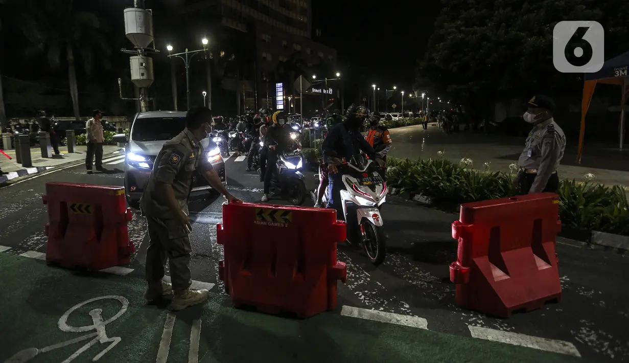 Petugas gabungan berjaga saat berlangsungnya Crowd Free Night di kawasan Bundaran HI, Jakarta, Jumat (31/12/2021). Polda Metro Jaya memberlakukan pengendalian mobilitas Crowd Free Night pada malam Tahun Baru 2022 yang berlangsung mulai pukul 22.00-04.00 WIB. (Liputan6.com/Johan Tallo)