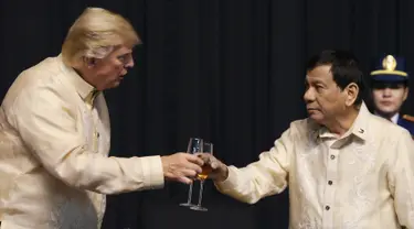 Presiden AS, Donald Trump bersulang dengan Presiden Filipina, Rodrigo Duterte dalam acara makan malam bersama konferensi ASEAN ke-31 di Manila, Minggu (12/11). Trump mengenakan pakaian resmi Filipina yaitu Barong Tagalog. (Athit Perawongmetha/Pool via AP)