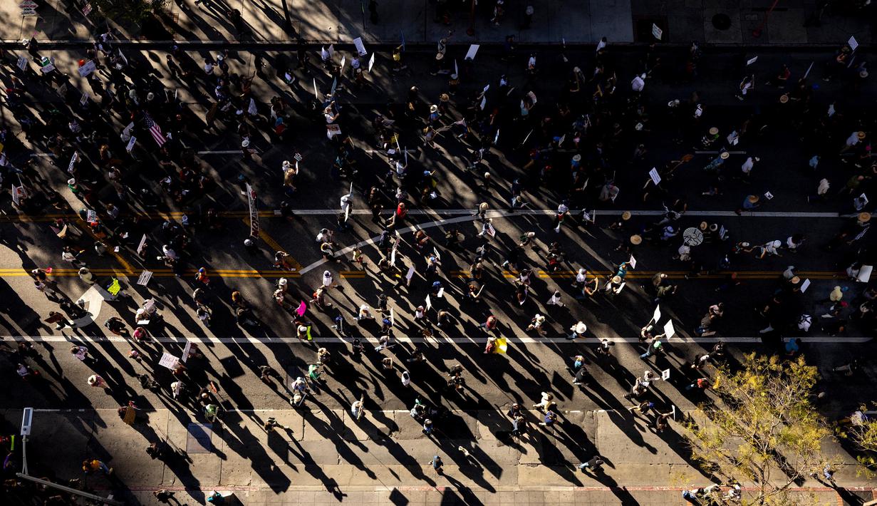 Pengunjuk rasa menyuarakan kekhawatiran atas kebijakan Trump yang merusak institusi demokrasi yang menjadi fondasi negara Amerika Serikat. (ETIENNE LAURENT/AFP)