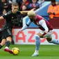 Gelandang Arsenal, Leandro Trossard, mendapatkan pengawalan ketat dari gelandang Aston Villa, Dougas Ruiz, pada laga pekan ke-24 Premier League 2022/2023 yang digelar di Villa Park, Sabtu (18/2/2023) malam WIB. (AFP/Geoff Caddick)