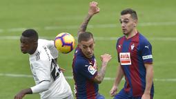 Striker Real Madrid, Vinicius Junior, berebut bola dengan gelandang Eibar, Ruben Pena, pada laga La Liga di Stadion Ipurua, Eibar, Sabtu (24/11). Eibar menang 3-0 atas Madrid. (AFP/Ander Gillenea)
