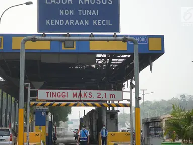 Petugas terlihat di dekat Gerbang Pejompongan tol dalam kota yang rusak akibat dibakar massa di Jakarta, Rabu (25/9/2019). Terbakarnya gerbang tol tersebut saat unjuk rasa yang menolak UU KPK dan RUU KUHP di depan gedung DPR Senayan berujung ricuh. (Liputan6.com/Immanuel Antonius)