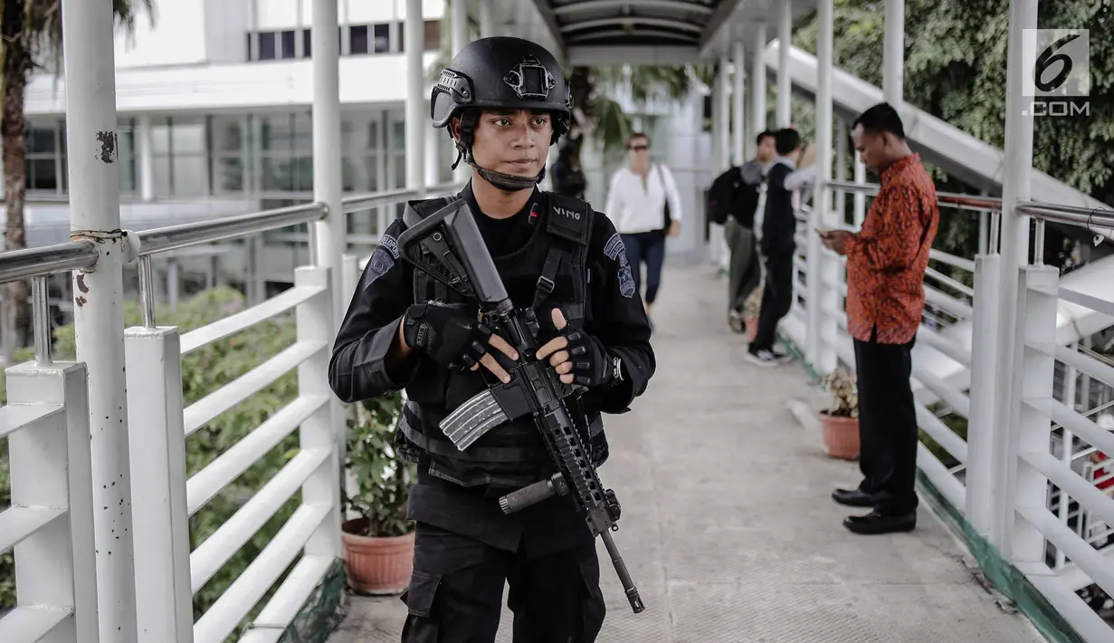 Seorang anggota Brimob bersenjata lengkap berjaga di JPO kawasan Bunderan HI, Jakarta, Jumat (11/5). Penjagaan tersebut dilakukan untuk antisipasi kegiatan Aksi 115 Pembebasan Baitul Maqdis yang berpusat di Monas. (Liputan6.com/Faizal Fanani)