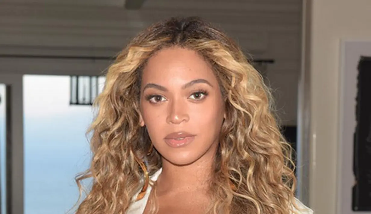 Foto tersebut tampak elegan dengan latar belakang bunga-bunga yang beraneka warna. Ia juga mengenakan selendang berwarna biru yang disangkutkan pada bagian belakang  di kepalanya. (Instagram/Beyonce)