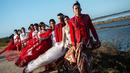 Model mengenakan busana kebaya bertema merah putih saat fashion show di tanggul Lapindo Porong, Sidoarjo, Jawa Timur, Selasa (13/8/2019). Peragaan busana yang menampilkan busana kebaya tersebut untuk memeriahkan HUT ke-74 kemerdekaan RI. (Photo by JUNI KRISWANTO / AFP)