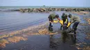 Tentara Sri Lanka membersihkan tumpahan minyak di sebuah pantai di Uswetakeiyawa, Kolombo, Senin (10/9). Pemerintah Sri Lanka mengerahkan ratusan tentara dan penjaga pantai untuk membersihkan tumpahan minyak. (AP Photo/Eranga Jayawardena)