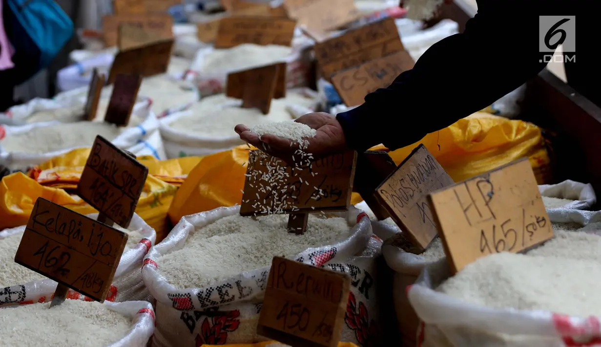 Pedagang melihat beras dagangannya di Pasar Induk Cipinang, Jakarta, Senin (25/9). Pedagang beras Cipinang sudah menerapkan dan menyediakan beras medium dan beras premium sesuai harga eceran tertinggi (HET). (Liputan6.com/Angga Yuniar)
