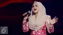 Penampilan Siti Nurhaliza saat membawakan lagu saat Konser Raya 21 Tahun Indosiar, Istora Senayan, Jakarta (11/1/2016). Tampil sederhana mengenakan busana hijba berwarna cokelat bertabur kembang berwarna merah. (Liputan6.com/Gempur M Surya)