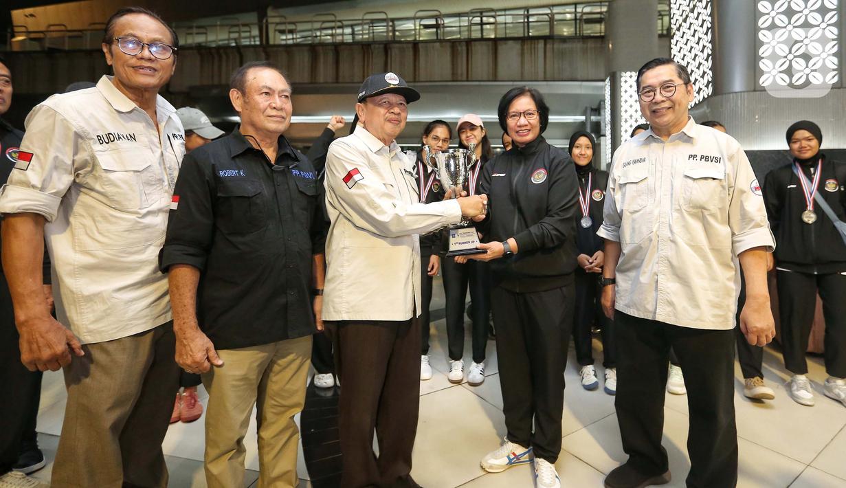 Manajer tim voli putri Indonesia, Ernita Pongky (kedua kanan) menyerahkan piala ke Wakil Ketua Umum PP PBVSI, Irjen Pol (purn) Drs. Djoko Sardono yang didampingi Dewan Pengawas PBVSI Brigjen Pol (Purn) Drs. Robert Kodong serta Wakil Sekjend PBVSI, Gilang Iskandar. (Liputan6.com/Angga Yuniar)