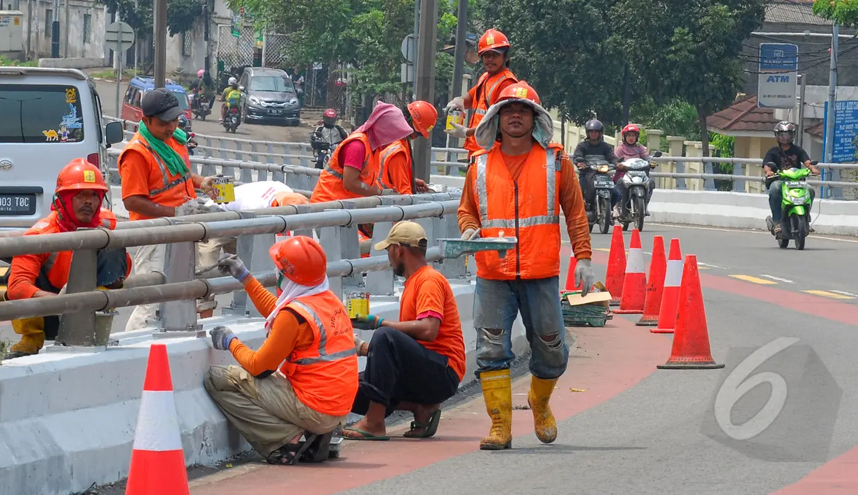 Sejumlah petugas Suku Dinas Pekerjaan Umum  melakukan peremajaan dengan melakukan pengecatan besi pembatas Fly Over di kawasan Cakung, Jakarta,  Rabu (1/4/2015). Panjang pembatas mencapai 120 meter (Liputan6.com/Yoppy Renato)