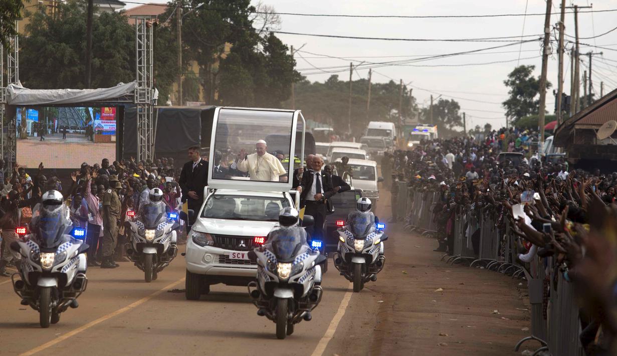 Ribuan warga Uganda berbaris dijalan memberikan sambutan yang meriah untuk Paus Francis yang ingin berceramah di kuil Uganda Martir di Namugongo, Uganda, (28/11). (REUTERS/Edward Echwalu)