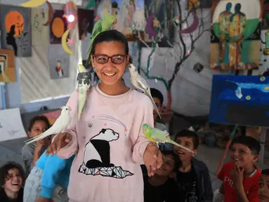 Anak-anak pengungsi Palestina mengikuti sesi dukungan psikologis di sebuah studio seni yang menggunakan hewan peliharaan dan burung di daerah Al-Zawaida, Jalur Gaza Tengah, pada Selasa 21 April 2026. Sejumlah anak-anak pengungsi Palestina mengikuti sesi konseling psikologis di sebuah studio seni di daerah Al-Zawaida, Jalur Gaza Tengah, pada Selasa 21 April 2026. (Eyad Baba/AFP)