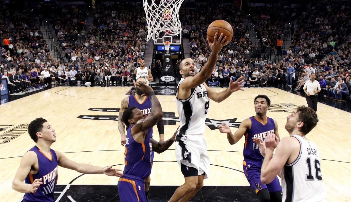 Pemain San Antonio Spurs, Tony Parker #9 melakukan tembakan saat dihadang para pemain Phoenix Suns pada laga NBA di AT&T Center, (28/12/2016). (Reuters/Soobum Im-USA TODAY Sports)