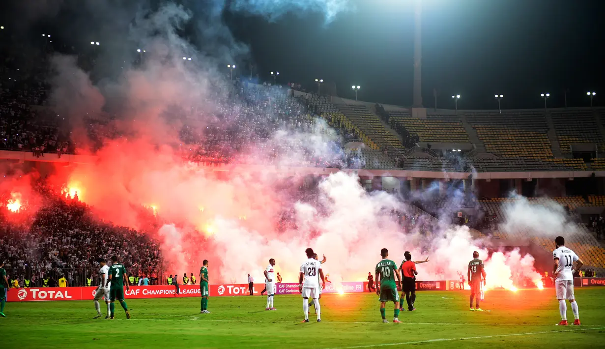 Suporter melemparkan suar saat pertandingan antara klub Mesir, Zamalek dan klub Libya, Al Ahly Tripoli pada lanjutan Grup B Liga Champion Afrika di Army Stadium, Alexandria, Mesir, (9/7). (AFP Photo/Khaled Desouki)