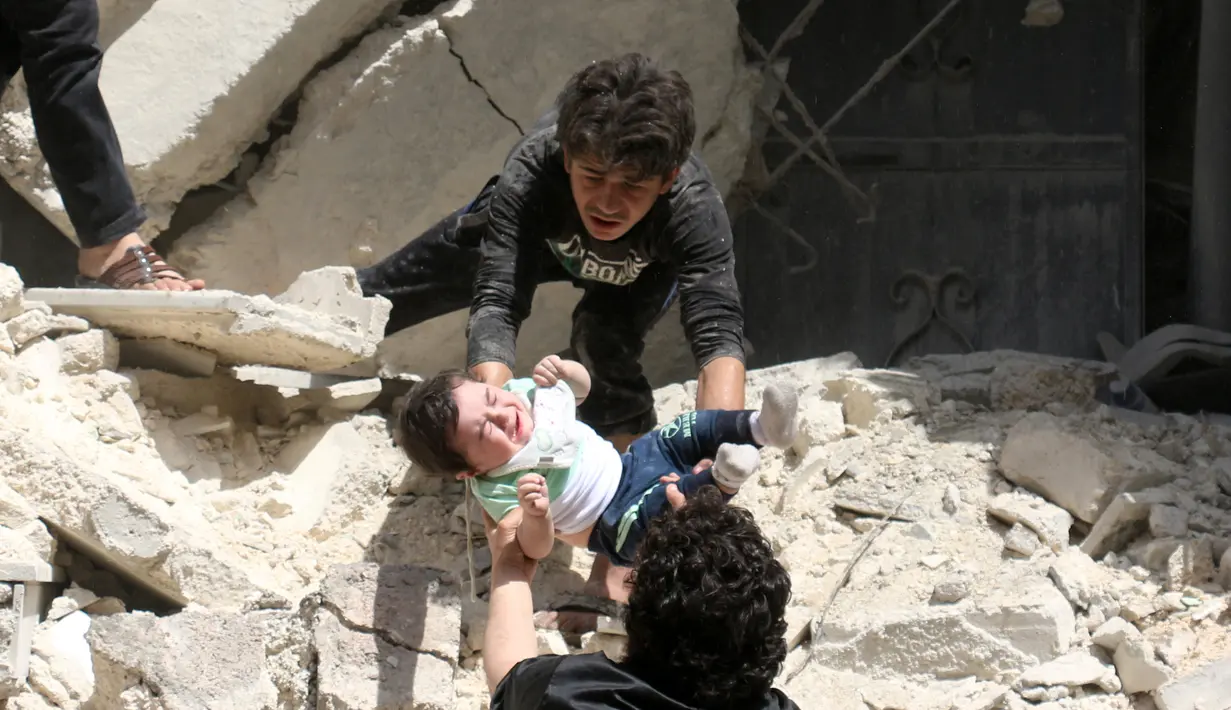 Relawan memberikan bayi kepada temannya setelah serangan udara di kota Suriah bagian utara, Aleppo, Kamis (28/4). Penyelamatan bayi berlangsung dramatis melalui tangga yang nyaris ambruk usai serangan udara. (AFP PHOTO / Ameer ALHALBI)