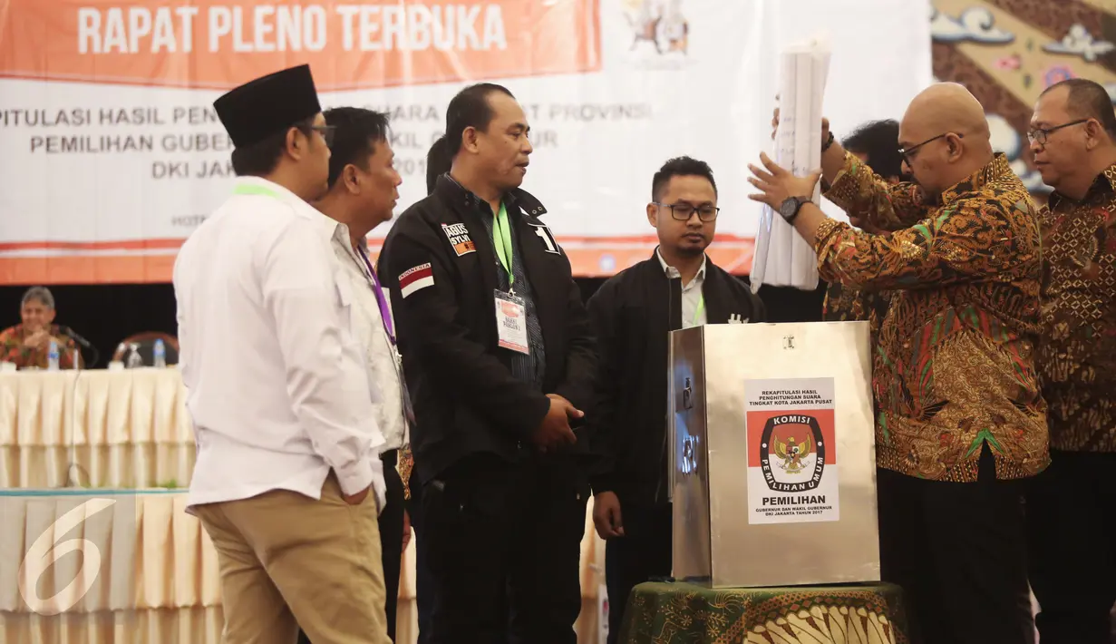 Petugas memasukan berkas kedalam kotak usai menggelar rekapitulasi penghitungan sura tingkat provinsi Pilkada DKI Jakarta di Grand Sahid, Jakarta, Minggu (26/2). (Liputan.com/Faizal Fanani)