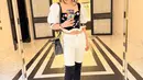 Shandy Aulia membagikan mirror selfienya yang menawan dalam balutan cropped top unik berlengan balon, dipadu celana jeans putih, dan high boots hitam. [Foto: Instagram/shandyaulia]