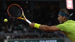 Petenis Spanyol, Rafael Nadal berusaha mengembalikan bola pukulan Novak Djokovic dari Serbia dalam pertandingan perempat final turnamen French Open 2022 di stadion Roland Garros di Paris, Rabu (1/6/2022). Nadal berhasil melaju ke semifinal usai mengalahkan Djokovic dengan skor 6-2, 4-6, 6-2, 7-6(4). (AP Photo/Jean-Francois Badias)