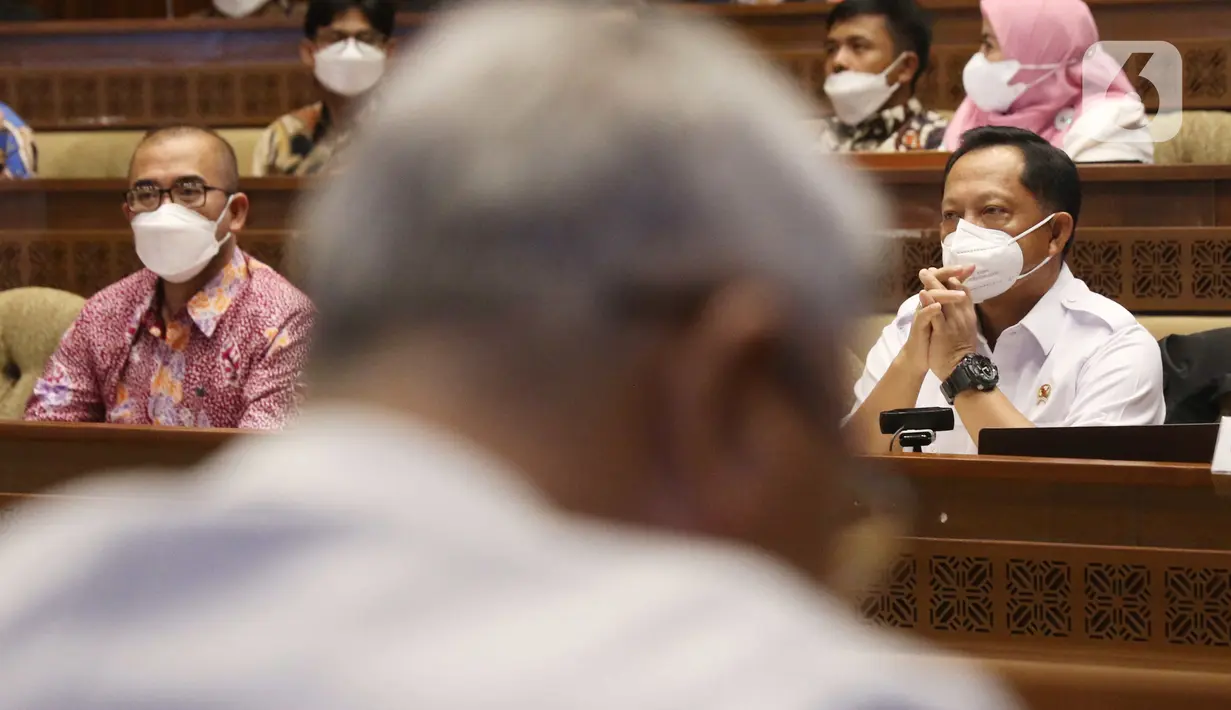 Menteri Dalam Negeri Tito Karnavian bersama Ketua KPU Hasyim Asyari saat rapat kerja dengan Komisi II DPR RI di Kompleks Parlemen, Jakarta, Rabu (13/4/2022). Raker tersebut membahas persiapan pemilu serentak pada 2024. (Liputan6.com/Angga Yuniar)