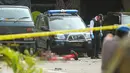 Polisi memeriksa jenazah seorang yang diduga sebagai pelaku bom bunuh diri di Mapolrestabes Medan, Sumatera Utara, Rabu (13/11/2019). Satu orang terduga pelaku bom bunuh diri tewas di lokasi kejadian. (ATAR/AFP)