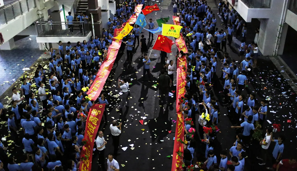 Sejumlah siswa melukan parade untuk menghilangkan stres jelang ujian tahunan "Gaokao" di Haikou, China (4/6). Mereka melakukan parade ini dua hari sebelum ujian tahunan "Gaokao" atau ujian masuk perguruan tinggi di China. (AFP)