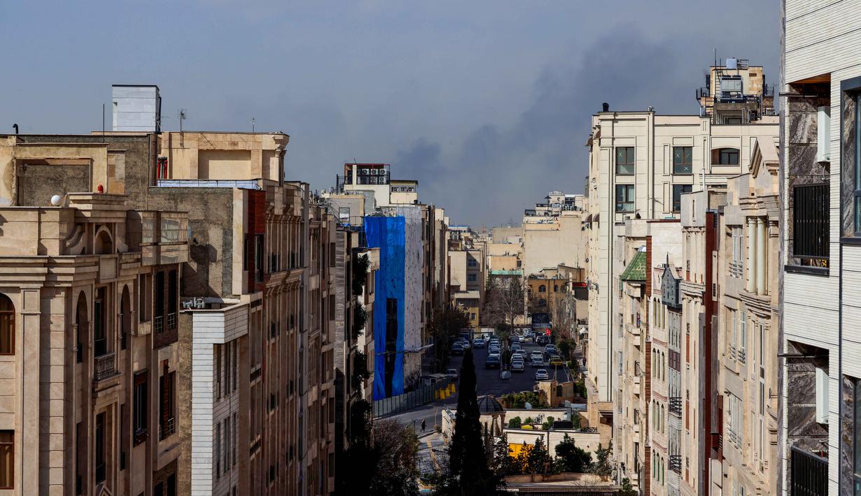 Situasi di Teheran dilaporkan mencekam setelah suara ledakan terdengar di beberapa titik kota. Tampak dalam foto, kepulan asap membubung setelah ledakan yang dilaporkan terjadi di Teheran, Iran, pada 28 Februari 2026. (ATTA KENARE/AFP)