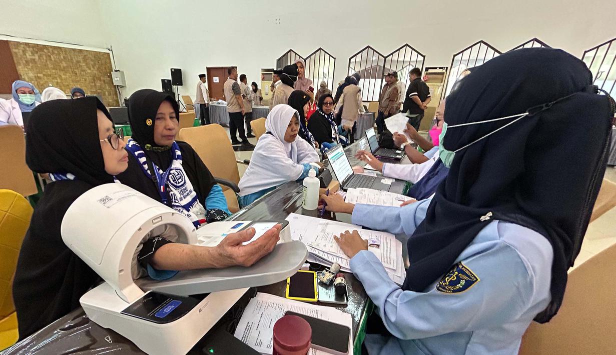 Petugas memeriksa kesehatan calon haji setibanya di Asrama Haji Pondok Gede, Jakarta, Selasa (21/4/2026). Sebanyak 393 jemaah haji kelompok terbang (kloter) pertama embarkasi Jakarta-Pondok Gede (JKG 01) secara resmi mulai memasuki Asrama Haji Pondok Gede, Jakarta Timur. (merdeka.com/Arie Basuki)
