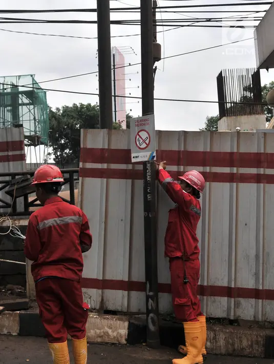 Pekerja dari Adhi Karya memasang tanda dilarang merokok di sekitar lokasi kebocoran pipa gas bumi, di depan Kantor BNN, Cawang, Jakarta, Selasa (13/3). (Merdeka.com/Iqbal S. Nugroho)