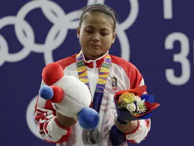 Lifter putri Indonesia, Lisa Setiawati saat naik podium usai mendapatkan medali perak SEA Games 2019 cabang angkat besi nomor 45 kg di Stadion Rizal Memorial, Manila, Minggu (1/12/2019). Dirinya meraih perak dengan total angkatan 169 kg. (Bola.com/M Iqbal Ichsan)