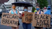 Sejumlah wanita memegang spanduk saat unjuk rasa atas kematian George Floyd oleh polisi di dekat TKP di Minneapolis, Minnesota, Amerika Serikat, Rabu (27/5/2020). Mayoritas demonstran hadir sambil membawa spanduk bertuliskan "I Can't Breathe" dan "Justice 4 Floyd". (Kerem Yucel/AFP)