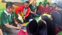 Peraih medali emas Asian Games Yuli Irawan membacakan dongeng kepada puluhan murid SD (Liputan6.com / M.Syukur)