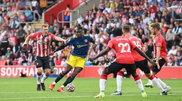 Pemain Manchester United Paul Pogba (kedua dari kiri) berlari ke arah gawang ketika pemain Southampton James Ward-Prowse (kiri) mengejar balik pada pertandingan Liga Inggris di Stadion St Mary, Southampton, Inggris, 22 Agustus 2021. Pertandingan berakhir imbang 1-1. (Glyn KIRK/AFP)