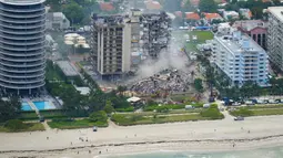 Petugas penyelamat bekerja di puing-puing Champlain Towers South Condo, Surfside, Miami, Florida, Amerika Serikat, Jumat (25/6/2021). Sebagian bangunan tepi pantai tersebut runtuh pada 24 Juni 2021. (AP Photo/Gerald Herbert)